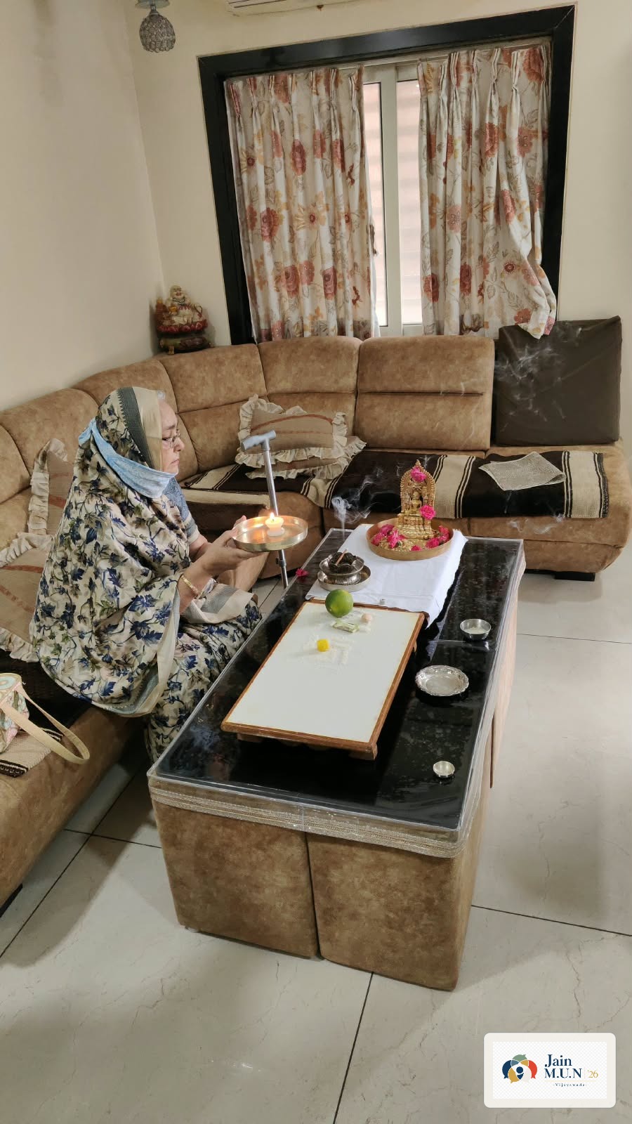 A devotee performs aarti during Ghar-Ghar Puja Seva.