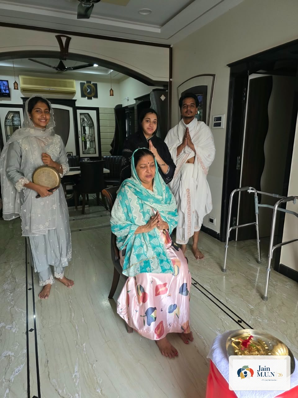 Jain MUN volunteers join a devotee in prayer.