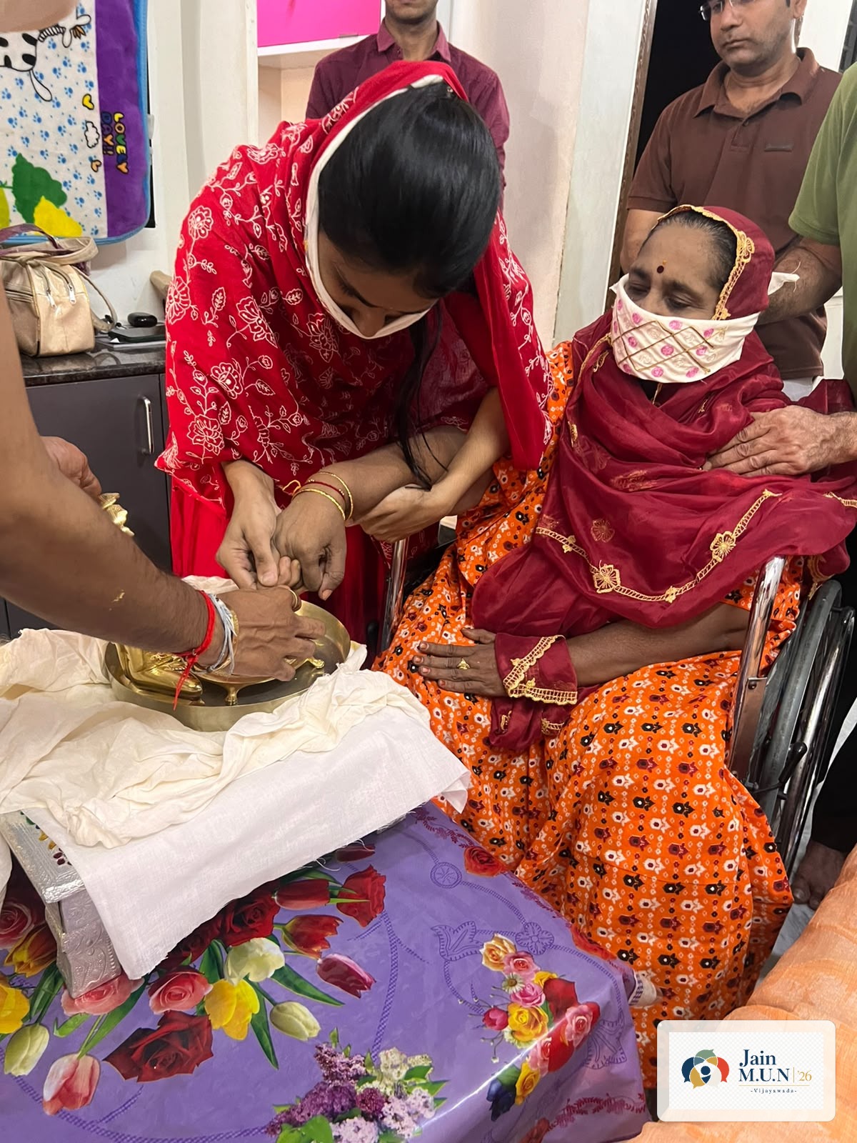 A devotee takes part in Pakshal with volunteer support.